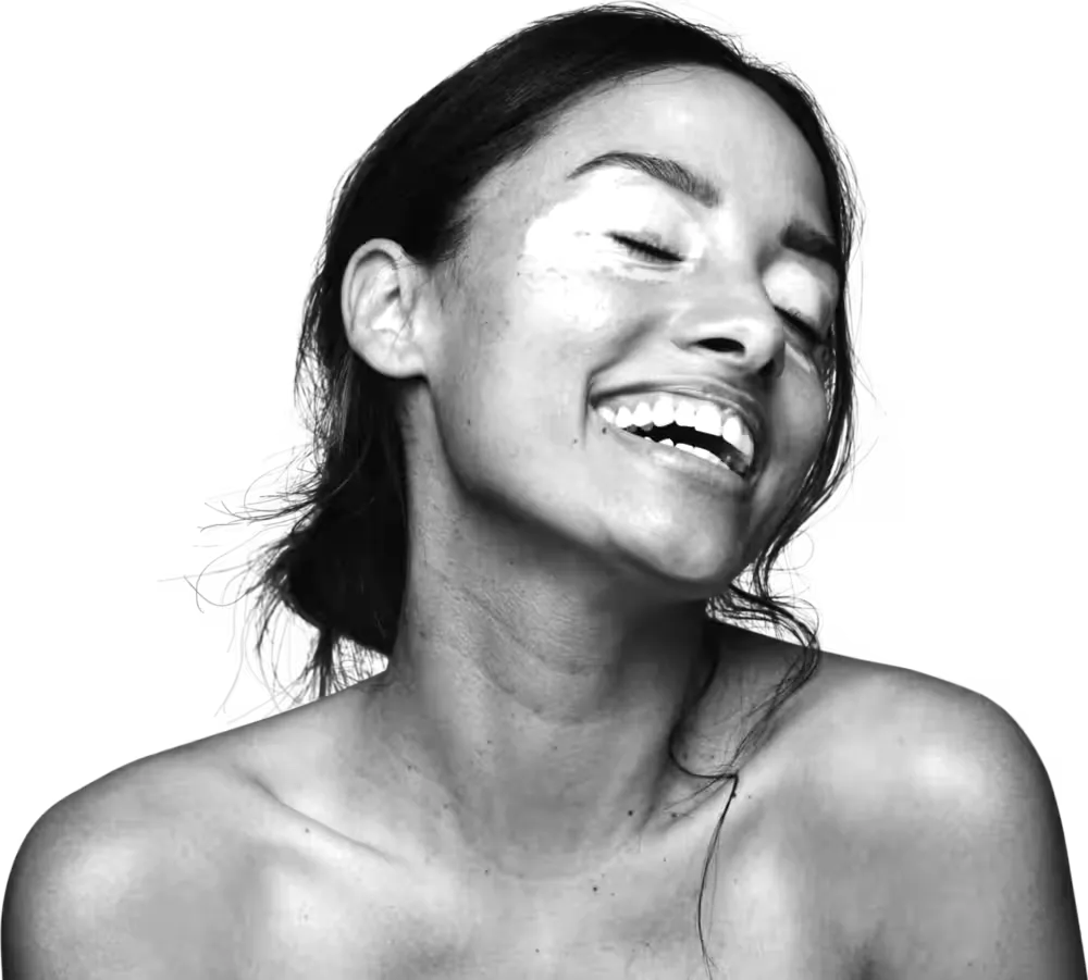Mujer sonriendo con los ojos cerrados y la cabeza hacia atrás, foto en blanco y negro