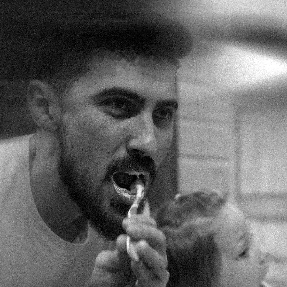 Papá y su hija cepillándose los dientes frente al espejo, en blanco y negro