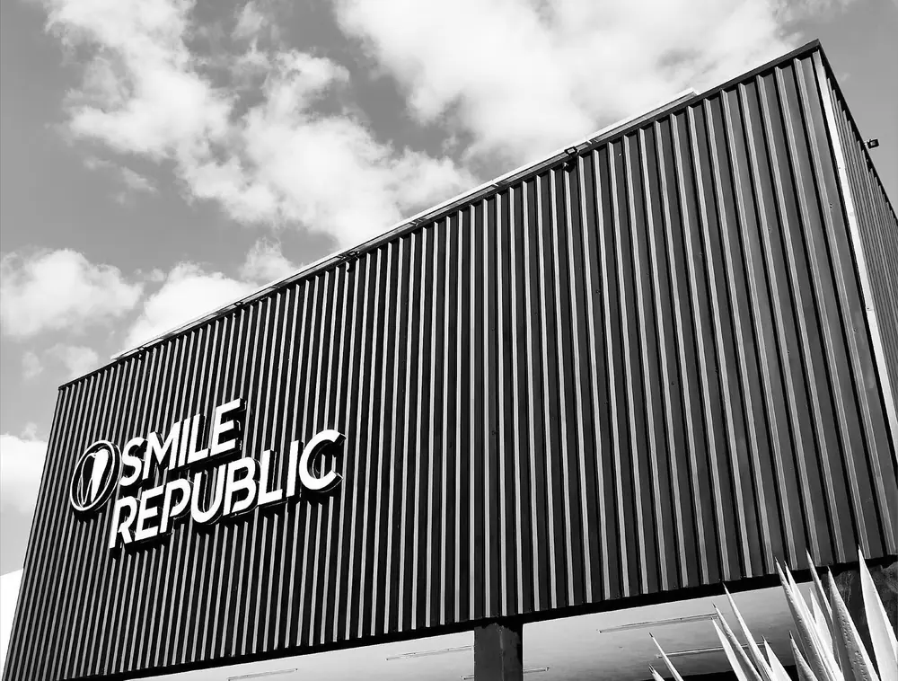 Fachada de Smile Republic en Fracc. Las Américas, con su letrero blanco sobre muro negro