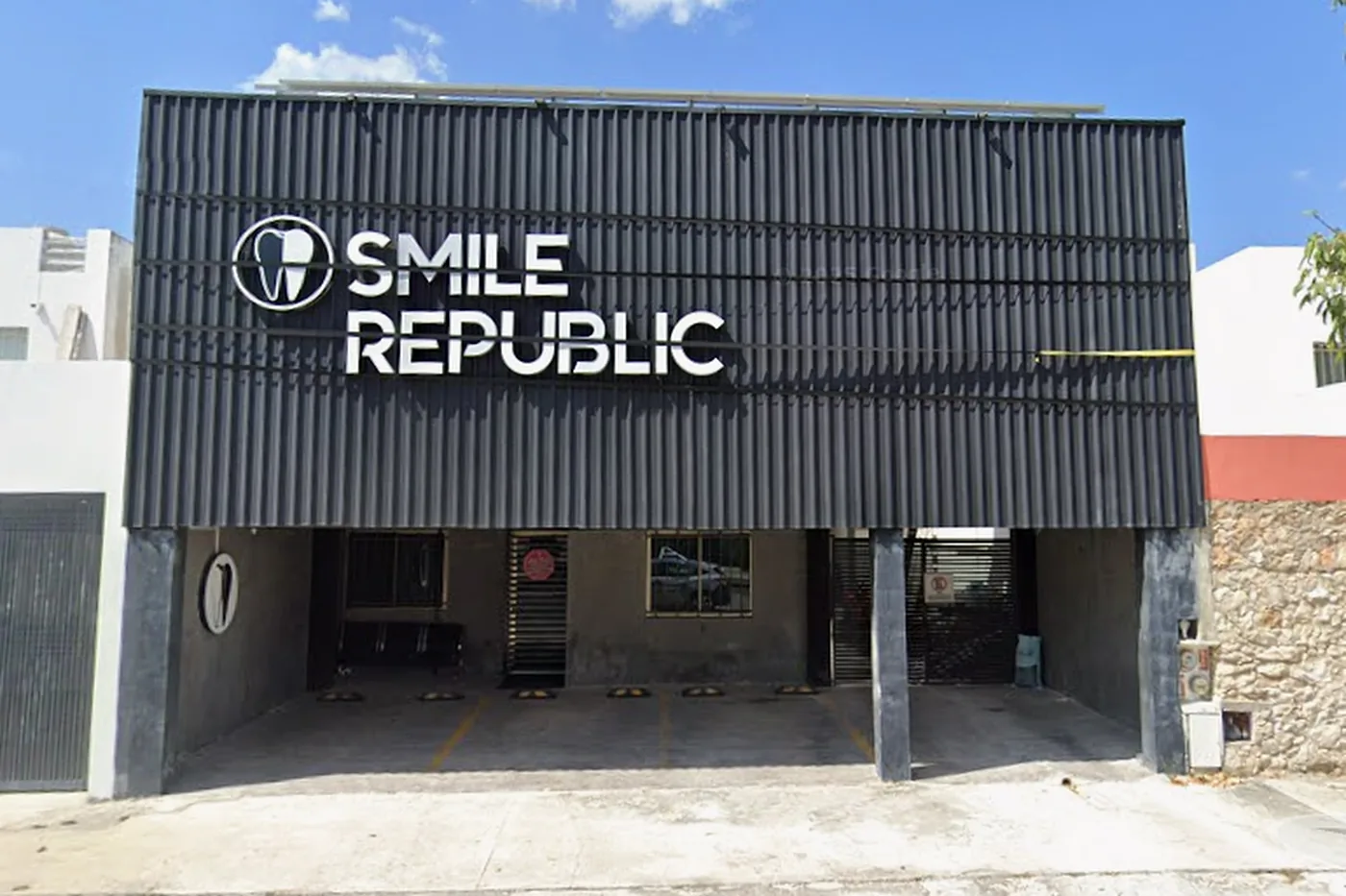 Fachada de Smile Republic Las Américas, con su letrero blanco sobre muro negro