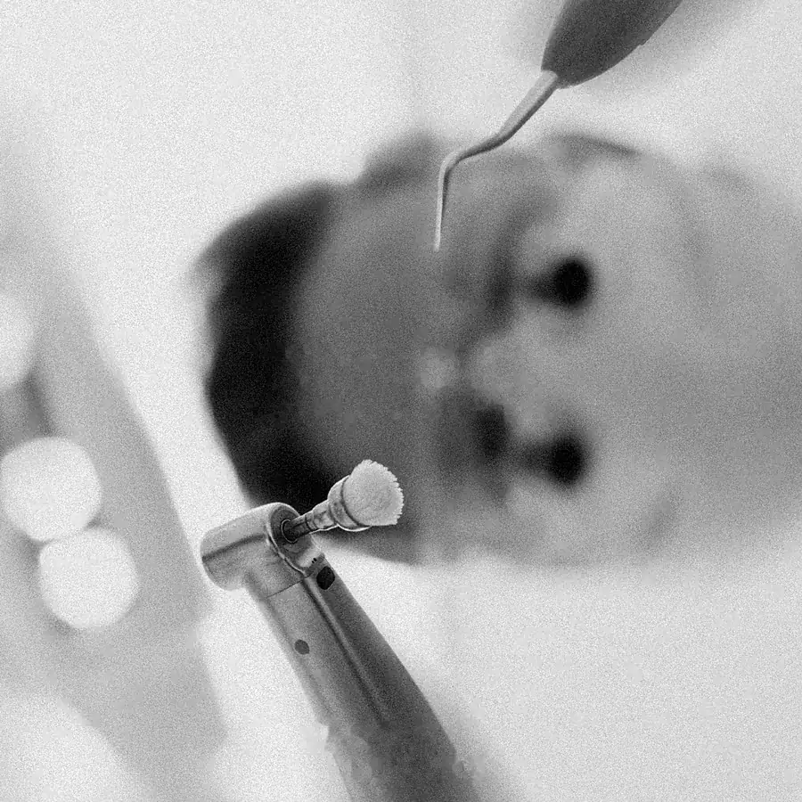 Instrumentos dentales de limpieza vistos en un espejo, en blanco y negro